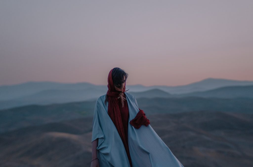 ToIranTour - a woman standing in mountain landscape - Iran dress code